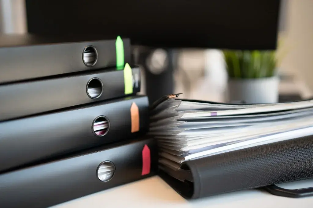 Organised binders and file folders of financial documents on a desk